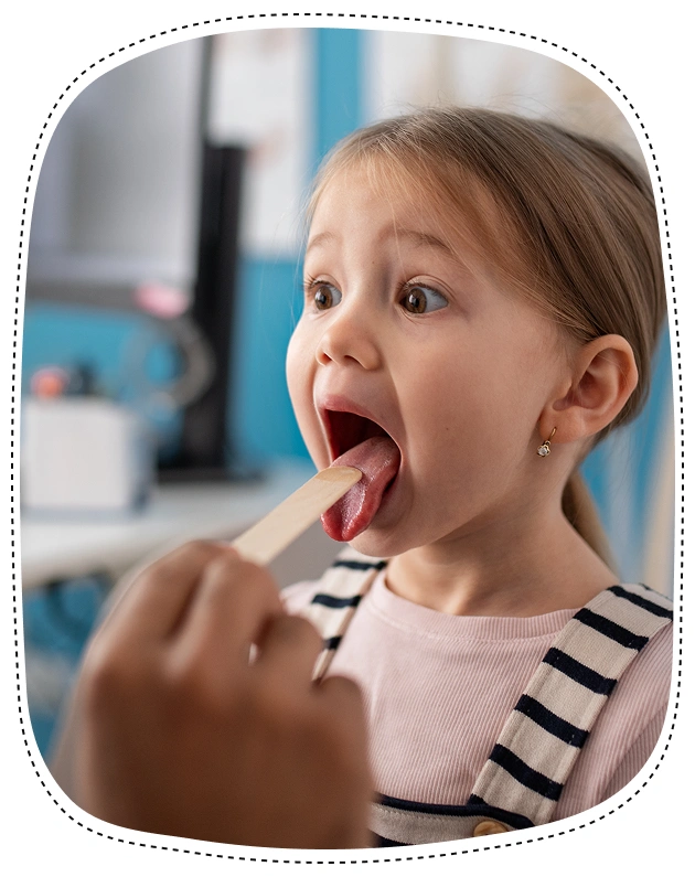 Young girl with tongue out during dental examination in pediatric dental office.