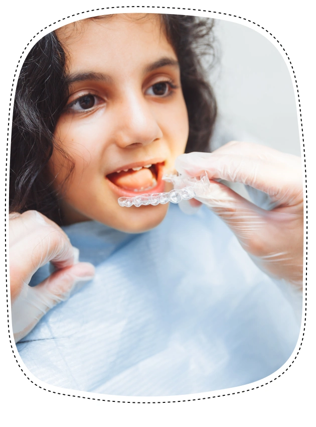 Young girl receiving dental examination from dentist's hands in clinical setting.