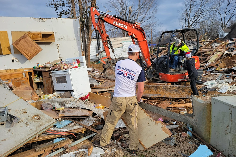 Construction equipment demolishes building debris at a junkyard or demolition site.