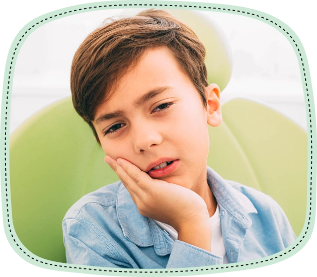 Young boy with hand to cheek, appearing to have tooth pain, against green background.