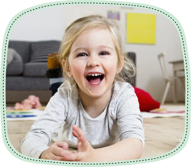 Happy young child smiling and laughing on playroom floor at home.